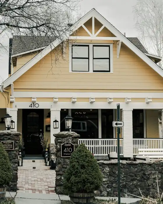 Yellow house with a large covered front porch and white railings